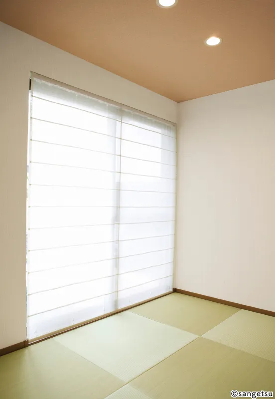 Phòng kiểu Nhật trải chiếu tatami, trần dán giấy màu nâu nhạt ấm có đèn âm trần, tường trắng và rèm xếp màu trắng